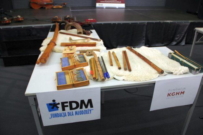 Instrumenty muzyczne na  stole z podpisem Fundacja dla młodzieży stole z podpisem