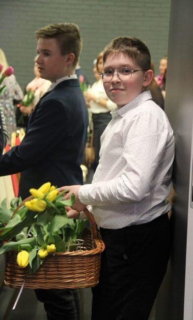 Chłopiec rozdający Paniom kwiatki