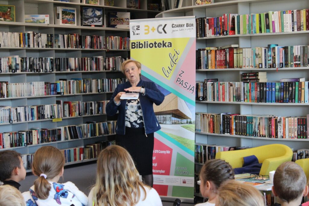 Renata Piątkowska na tle roll-up'u Biblioteka Ludzi z Pasją