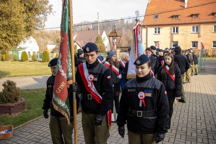Uczniowie klasy mundurowej ZSZiO w Kamiennej Górze ze sztandarem przed kościołem w Czarnym Borze
