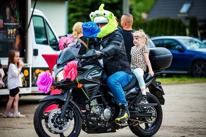 Motocyklista i dziecko podczas przejażdżki z okazji Gminnego Dnia Dziecka