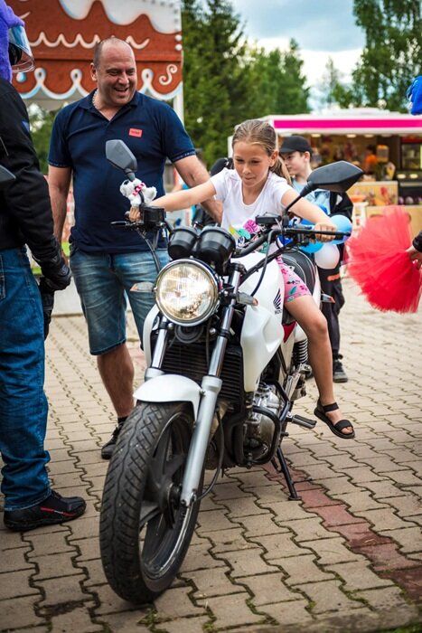Dziewczynka siedzi na motorze podczas Dnia Dziecka w Grzędach