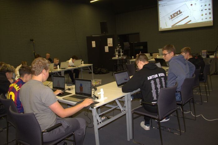 młodzież siedzi przed komputerami projektując w programie graficznym krasnale