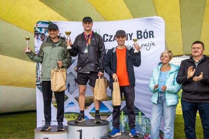 Uczestnicy biegu na podium z pucharami