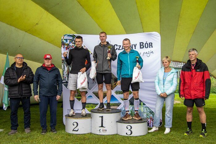 Uczestnicy biegu na podium z pucharami