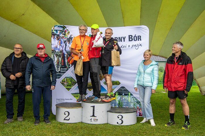 Uczestnicy biegu na podium z pucharami