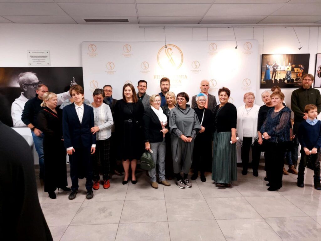 grupa ludzi pozuje do zdjęcia w holu filharmonii