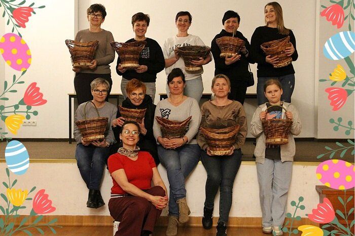 Uczestniczki warsztatów wikliniarskich na wspólnym zdjęciu z wyplecionymi przez siebie koszami wiklinowymi