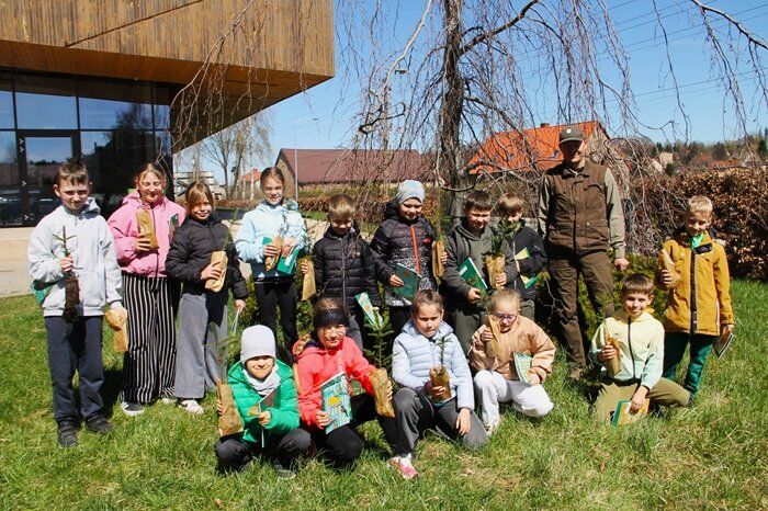Dzieci z GZSP w Czarnym Borze z dyplomami w rękach na wspólnym, zdjęciu z leśniczym