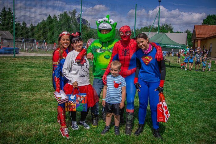 Motocykliści przebrani za Superbohaterów pozują do zdjęcia z dziećmi podczas Gminnego Dnia Dziecka